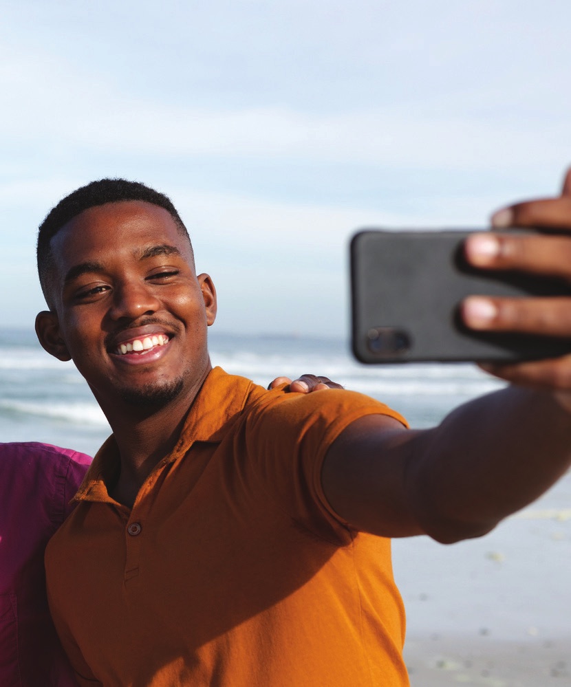 A young man taking a selfie at the beach