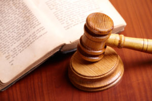 Old book and gavel on wooden desk
