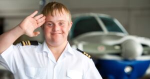 Pilot with down syndrome saluting in hangar.